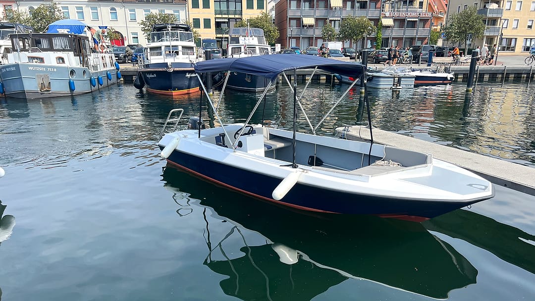 Detailansicht der Steuerkonsole eines Motorboots mit Bimini-Sonnendach.