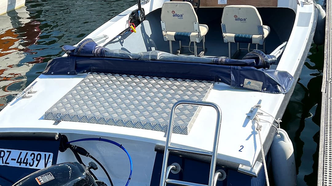 Blick auf die gepolsterten Sitzplätze und das Sonnendeck eines Motorboots.