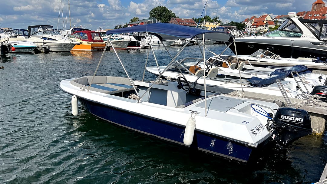 Führerscheinfreies Motorboot „Möwe“ mit blauem Sonnendach am Steg im Stadthafen Waren.