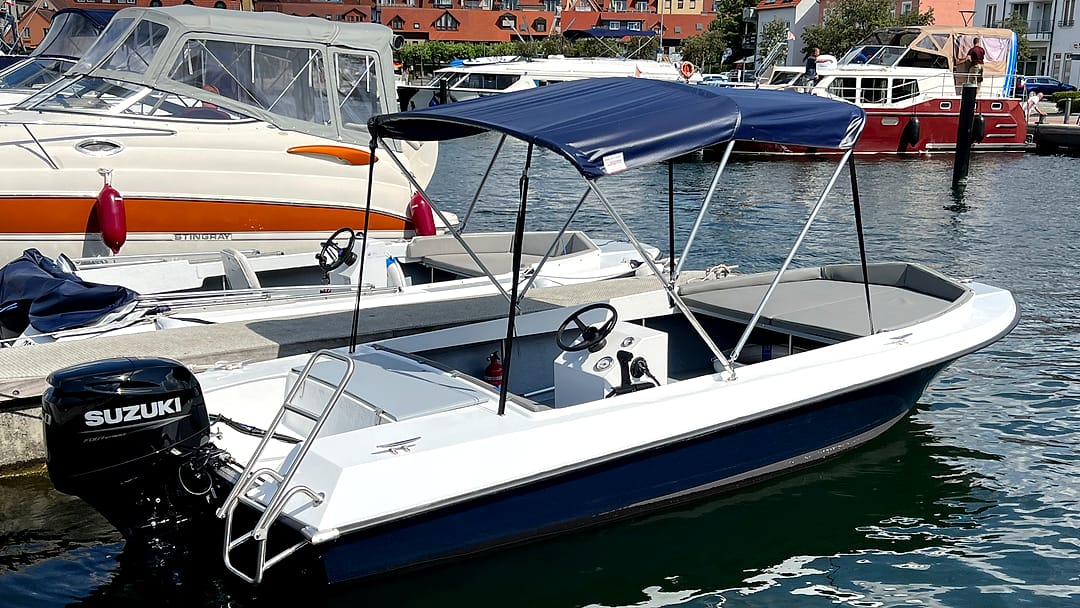 Geräumiges Komfort-Motorboot „Nordwind“ mit Sonnendach und offenem Deck am Steg in Waren.