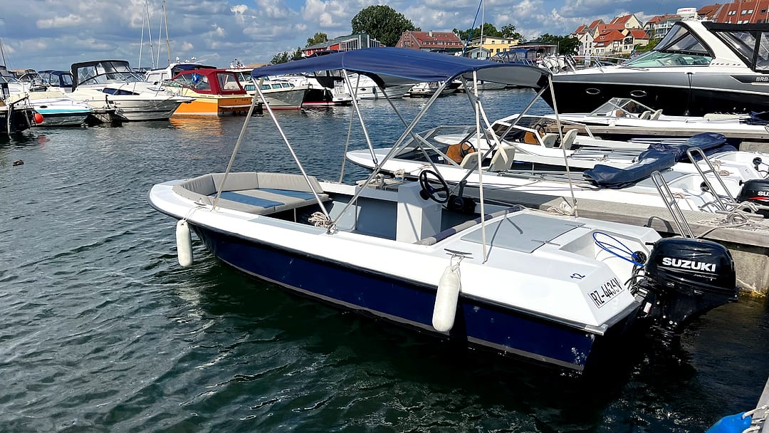Führerscheinfreies Konsolenboot „Seestern“ mit Bimini-Sonnendach vor der Kulisse von Waren an der Müritz.