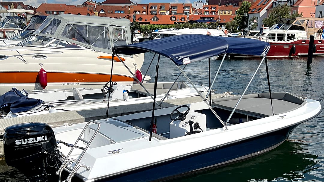 Komfortables Familienboot „Sonnendeck“ mit Bimini-Verdeck im sonnigen Stadthafen Waren.