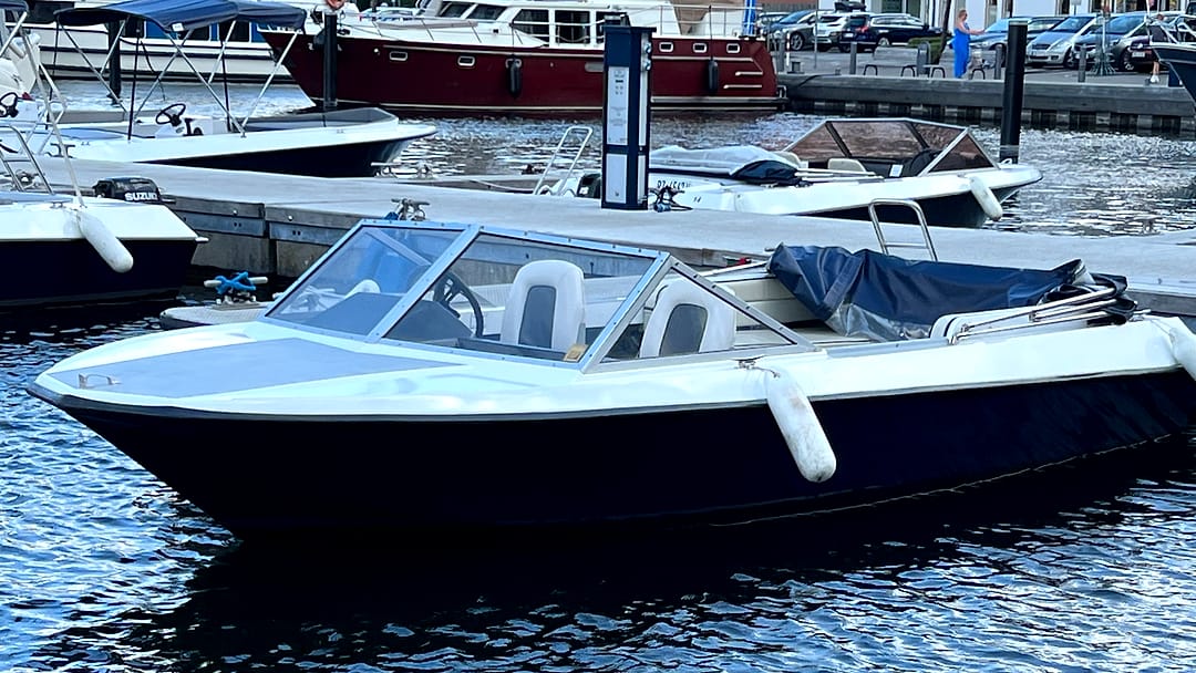 Sportboot „Sturmvogel“ mit Windschutzscheibe und Sportsitzen im Hafenbecken von Waren.
