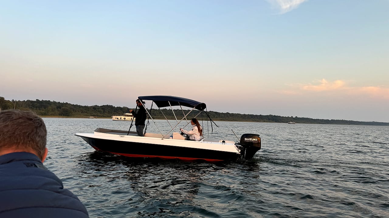 Kleines Motorboot auf der ruhigen Müritz im warmen Licht der Abendsonne.